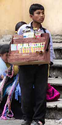 Un muchacho joven vendiedo tabaco y dulces